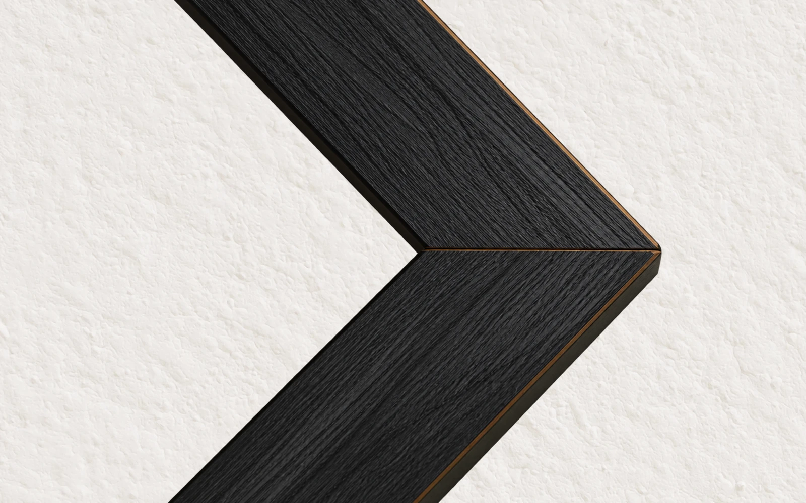 The mitred corner of a black stained wood picture frame