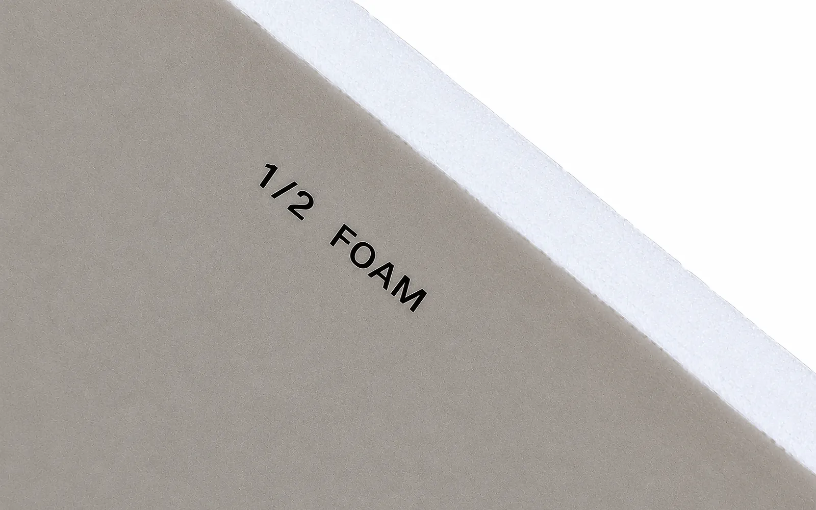 The back of a grey board printed 1/2 foam, its thick white foam-core edge showing