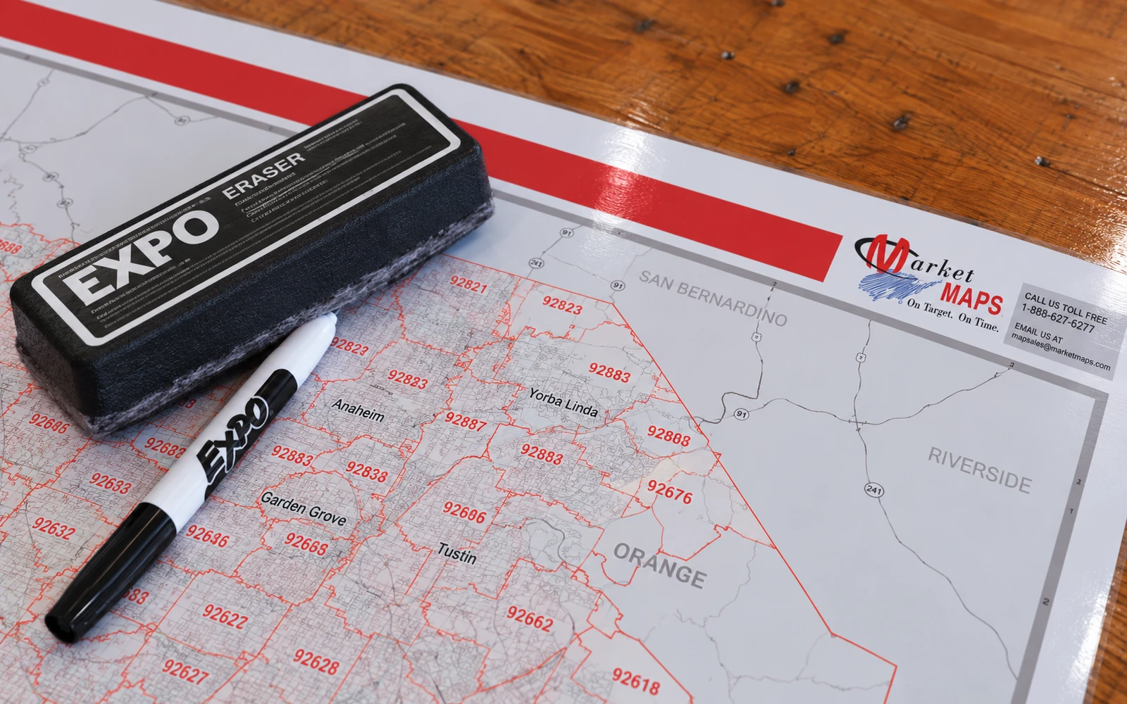 An eraser and a dry-erase marker lying on a glossy laminated ZIP code map