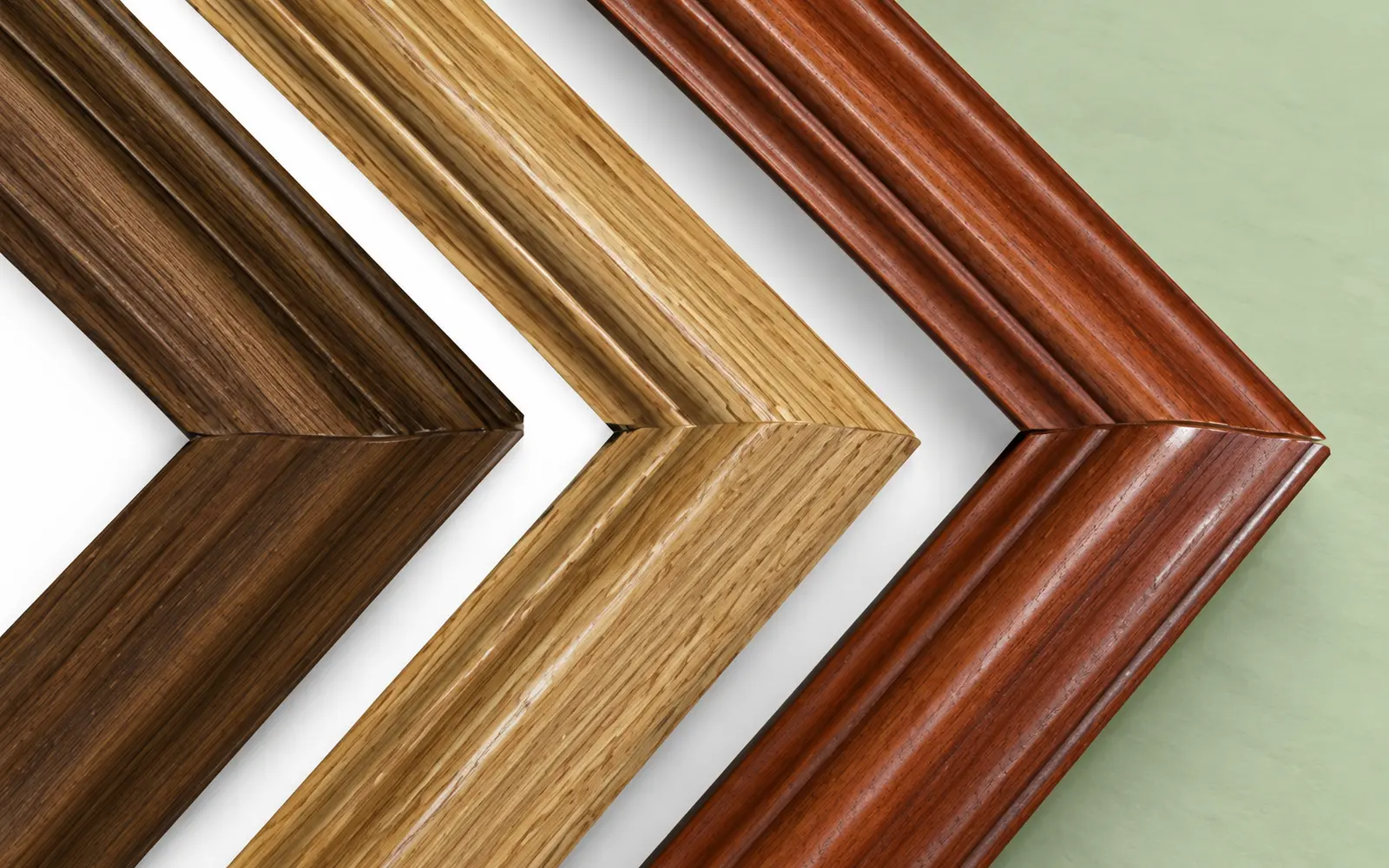 Three ornate hardwood frame corners: dark oak, cherry and light oak