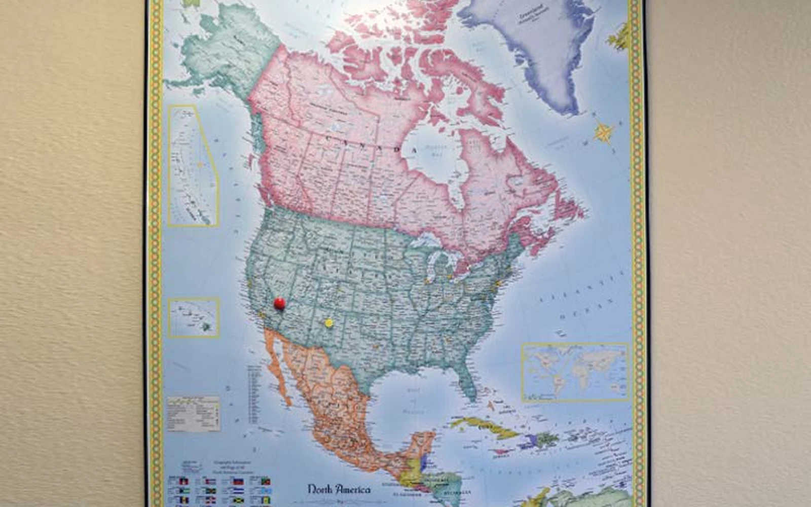 A framed magnetic map of North America with magnets placed on it